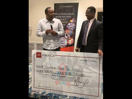 Caribbean Regional Director of the AIDS Healthcare Foundation Dr Kevin Harvey (left) hands over a cheque for $775,000 to the manger of the Sunbeam Home for Boys, Desmond Whitely, during a luncheon in observance of International Men’s Day on Saturday at T