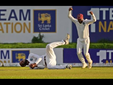 West Indies bowler Roston Chase takes a catch to dismiss Sri Lanka's Dimuth Karunaratne during the day one of their second test cricket match in Galle, Sri Lanka, today.