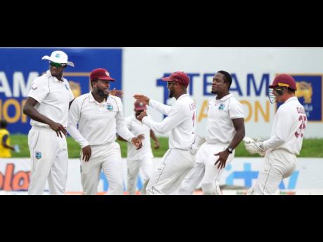 West Indies team members congratulate Kyle Mayers (second left) for a run out to dismiss Sri Lankan captain Dimuth Karunaratne, during day three of their second Test cricket match in Galle, Sri Lanka, yesterday.