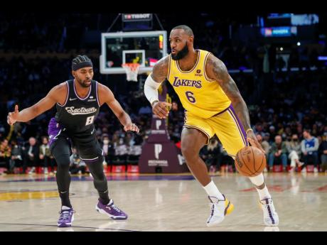 Los Angeles Lakers forward LeBron James (right) drives past Sacramento Kings forward Maurice Harkless during the first half of an NBA basketball game in Los Angeles, California on Friday, November 26.