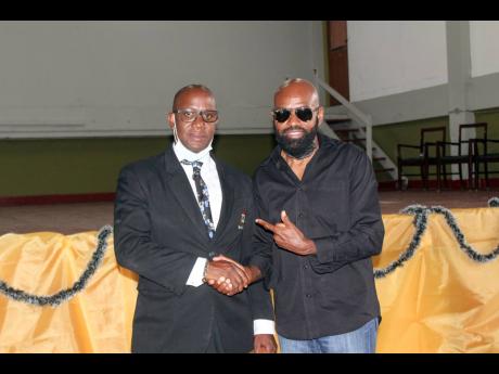 Credit: Stephanie Lyew Principal of Tivoli Gardens High School Marvin Johnson (left) and Cleve ‘Lt Stitchie’ Laing, president, Tivoli Gardens High School Alumni Track Corporation, shake hands after they both shared important messages with the school’s students and parents.