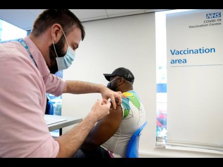 Credit: AP Britain says it will offer all adults a booster dose of vaccine within two months to bolster the nation’s immunity as the new omicron variant of the coronavirus spreads. New measures to combat variant came into force in England on Tuesday, with face cove
