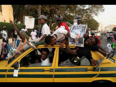 Supporters of The Gambia’s President Adama Barrow celebrate the results that give the lead to their candidate.