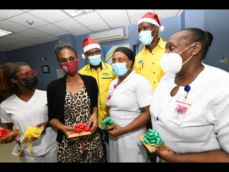 Credit: Rudolph Brown/Photographer Robert White (left, background) and Mark White (right, background), directors of the Sanmerna Foundation, share a light moment with nurses (from left, foreground) Lamoyje Fletcher, May Daley, Sian Smart, and Joan Cole after they were presented with spa gif