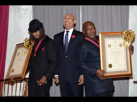 Governor General of Jamaica Sir Patrick Allen (centre) laughs as he is flanked by drummer Sly Dunbar (left) and bass guitarist Robbie Shakespeare after they received Gold Musgrave Medals in the field of music at the Institute of Jamaica.