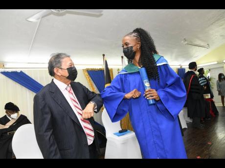 Dr Jamila McFarlane is greeted by keynote speaker Lascelles Chin after she received her doctoral award at the graduation ceremony recently. Dr McFarlane is one of four medical doctors who matriculated.