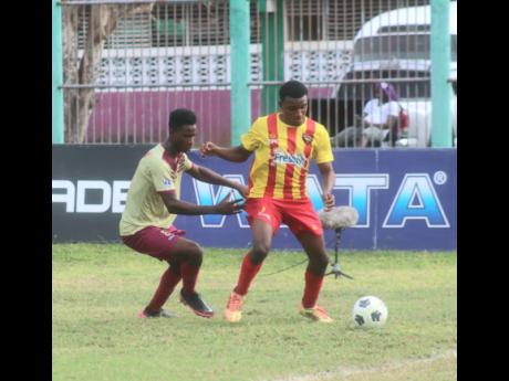 Devin Johnson (right), of Cornwall College, shielding the ball from Dylan Johnson of Herbert Morrison Technical High during the ISSA daCosta Cup match at the William Knibb Sports Complex on Tuesday, November 30. Cornwall won the match 1-0.