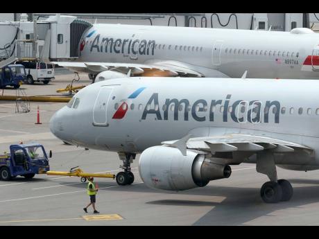 
American Airlines passenger jets prepare for departure on July 21, 2021, near a terminal at Boston Logan International Airport.