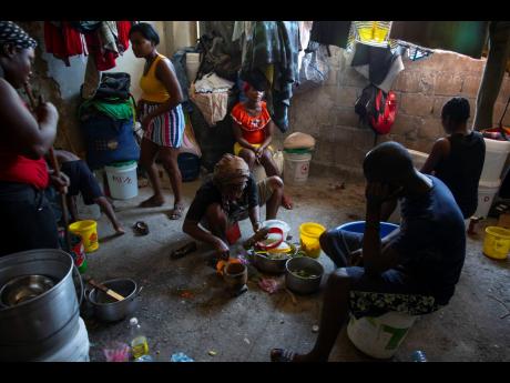 A woman prepares food at a shelter for families displaced by gang violence in Port-au-Prince, Haiti ,on Thursday.