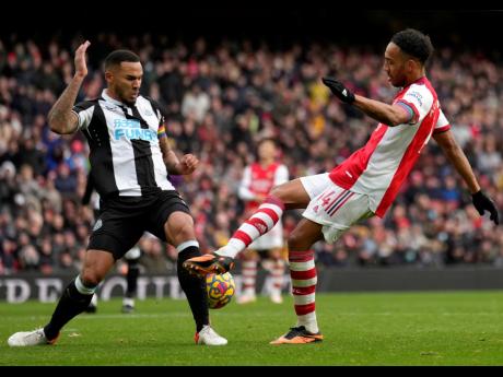 Newcastle's Jamaal Lascelles (left) duels for the ball with Arsenal's Pierre-Emerick Aubameyang during the English Premier League soccer match at Emirates stadium in London on Saturday, November 27.