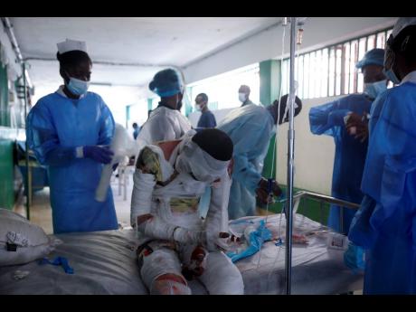 Health workers attend a patient at the Justinien University Hospital who was burned by a gasoline truck that overturned and exploded in Cap-Haitien, Haiti, on Tuesday.