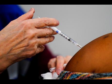 A health worker administers a dose of a COVID-19 vaccine during a vaccination clinic at the Keystone First Wellness Center in Chester, Pa, Wednesday, Dec 15.