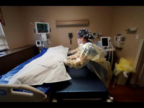 Medical staff move a COVID-19 patient who died onto a gurney to hand off to a funeral home van, at the Willis-Knighton Medical Center in Shreveport, Lousiana, on August 18.