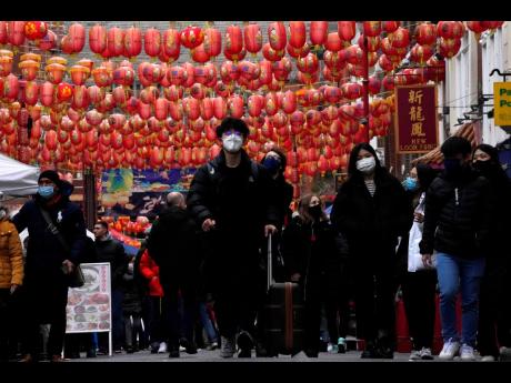 Shoppers stroll through Chinatown in London, Tuesday, December 21, 2021.