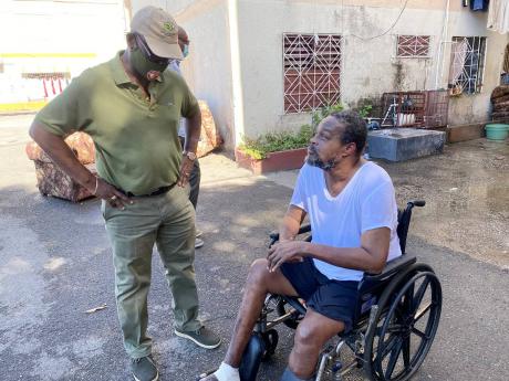 Kingston Western MP Desmond McKenzie interacts with Constantine Elliot in Tivoli Gardens during a roving Christmas treat on Tuesday.