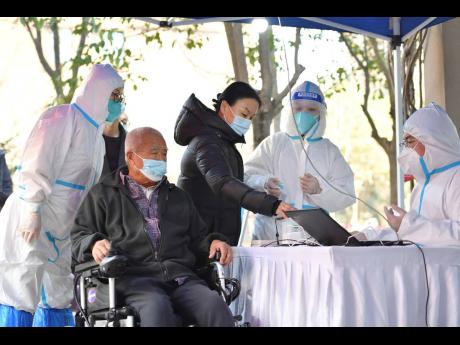 In this photo released by China’s Xinhua News Agency, people register for tests at a COVID-19 testing site in Xi’an in northwestern China’s Shaanxi Province, Tuesday, December 21, 2021. 