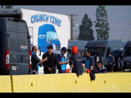 Amazon drivers wait next to a Crunch Time station as their logistics systems is offline at the Amazon Delivery Station in Rosemead, California, on December 7, when Amazon Web Services suffered a major outage.