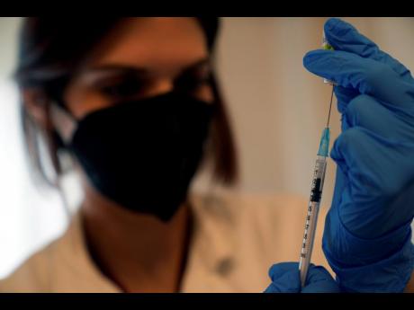 A nurse prepares a booster Pfizer-BioNTech vaccine against COVID-19.