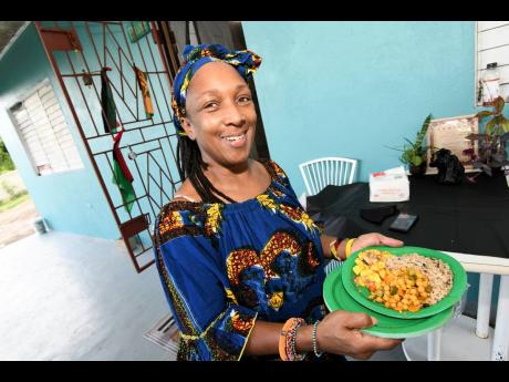 Credit: Rudolph Brown Sophia Newman-Walsh shows off a plate of food consumed during a traditional Kwanza celebration in Oracabessa,
St Mary.