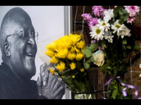 Flowers are placed alongside a photo of Anglican Archbishop Desmond Tutu at the St. George’s Cathedral in Cape Town, South Africa, Sunday, Dec. 26, 2021.
