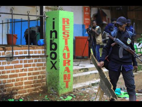 Police officers inspect the scene of a bomb explosion in Beni, eastern Congo Sunday Dec. 26, 2021. 