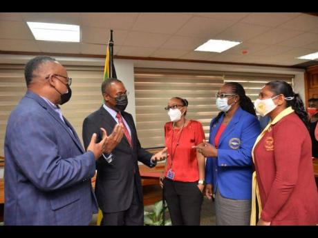 Minister of Finance and the Public Service Dr Nigel Clarke (second left) in discussion with representatives of the latest unions/bargaining units signing the Heads of Agreement for the Government’s 12-month, four per cent salary offer for April 2021 to M