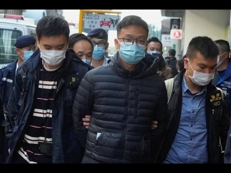 Editor of Stand News, Patrick Lam (centre), is arrested by police officers in Hong Kong, Wednesday, December 29. 