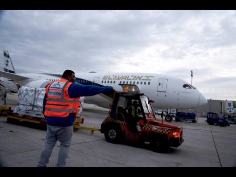 Ground crew move pallets of a shipment of Pfizer’s antiviral COVID-19 pill, Paxlovid, on arrival at Ben Gurion Airport near Tel Aviv, yesterday.