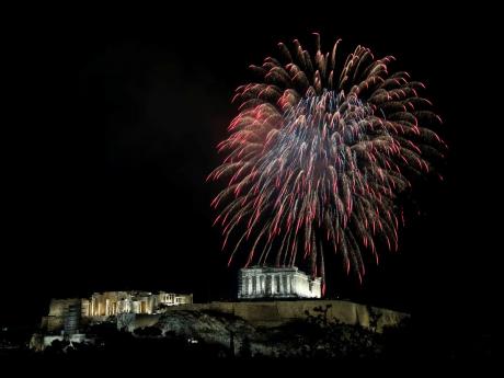 Fireworks explode over the ancient Parthenon temple at the Acropolis hill during New Year’s celebrations in Athens, Greece, on Saturday, January 1, 2022.