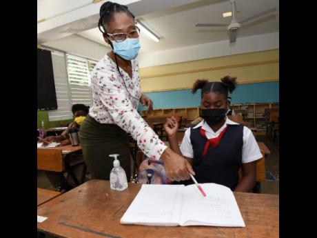 Roselyn Francis, grade six teacher at Red Hills Primary, goes through preparatory work with a student on Tuesday ahead of the 2022 Primary Exit Profile exams.