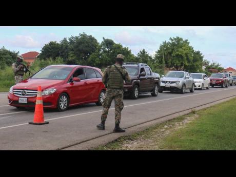 Army personnel monitoring a checkpoint in Greenwood at the border of Trelawny and St James late last year while a state of emergency was in effect the latter parish.