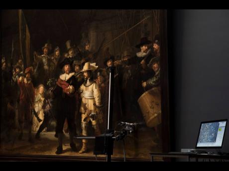 Credit: AP/ File A microscopic image enlarging a 4x6 millimetre, part of the painting on Rembrandt’s Night Watch, which will be restored next year in the public eye, is seen on a screen next to the painting at the Rijksmuseum in Amsterdam, Netherlands, 2018. Rembrandt va