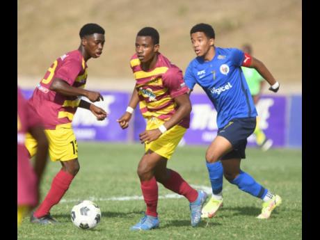 Credit: Ricardo Makyn
From left: Dinthill Technical’s Shamair Hutchinson look’s on while his team mate Shamar Martin dribbles away from Jamaica College captain Duncan McKenzie during the team’s ISSA Champions Cup semi-final at the Stadium East field on Satruday.