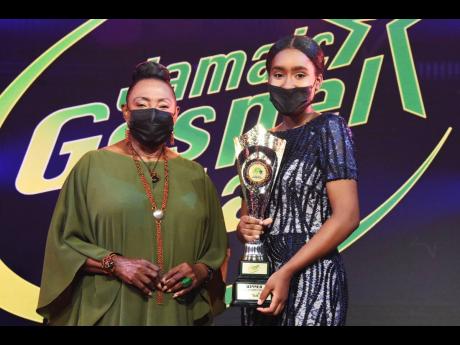 Credit: Contributed Erica Lumsden, winner of the Gospel Star Competition, happily holds on to her trophy as she stands alongside Minister of Culture, Gender, Entertainment and Sport Olivia Grange.