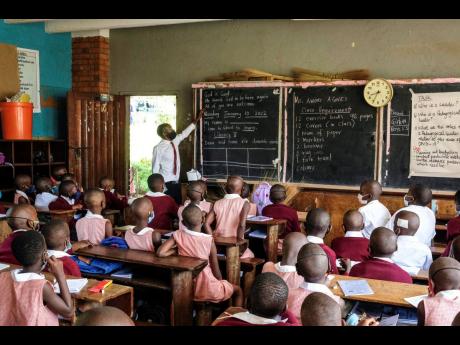 Pupils wear face masks as they attend class at Kitante Primary School in Kampala, Uganda yesterday.