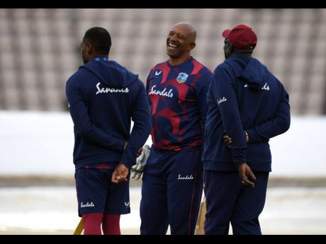 In this file photo, West Indies team coach Phil Simmons (centre) shares a laugh with members of his support staff before the start of the first Test match between England and the West Indies at the Ageas Bowl in Southampton, England, last year.  