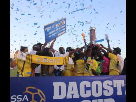 Garvey Maceo High School players celebrate with their ISSA daCosta Cup trophy.