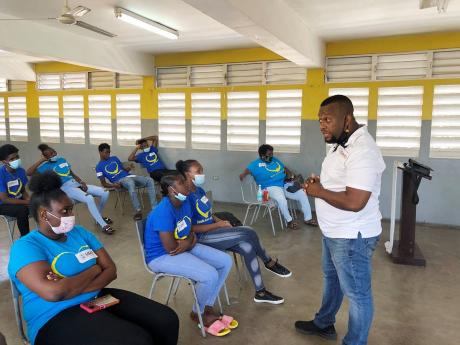 Credit: Asha Wilks Pastor Jayson Downer addresses a group of youngsters between the age of 16 and 24 years at a community development and skills training programme funded by USAID in Jones Town recently.
