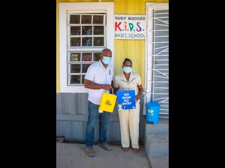 Steve Palmer, general operations manager, The Best Dressed Chicken Processing Plant, presents children’s masks, COVID-19 protocol signs, sanitiser, educational materials and a step closure garbage bin to principal of the Ruby Madden Basic School, Sylvia 