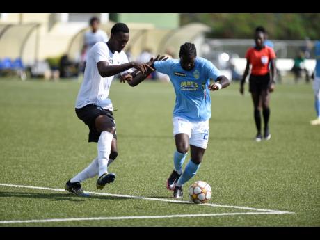 Devroy Grey (right) of Waterhouse dribbles past Jamoi Topey of Cavalier during a Jamaica Premier League match at the UWI-JFF Captain Horace Burrell Centre of Excellence yesterday. Waterhouse won 3-0.