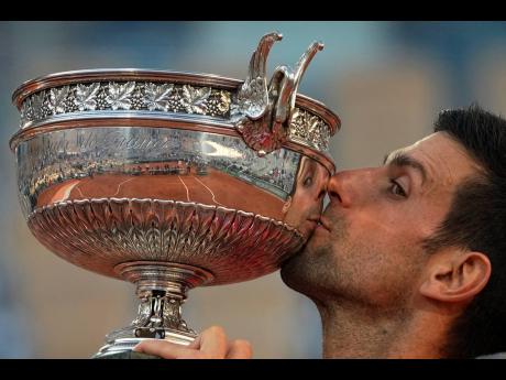 Credit: AP Serbia’s Novak Djokovic kisses the cup after defeating Stefanos Tsitsipas of Greece in the 2021 French Open final at Roland Garros stadium on Sunday, June 13, 2021 in Paris.