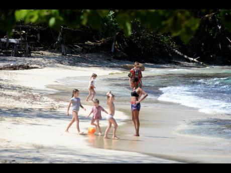 Leisure seekers enjoy the white sand of Winnifred Beach in Portland.