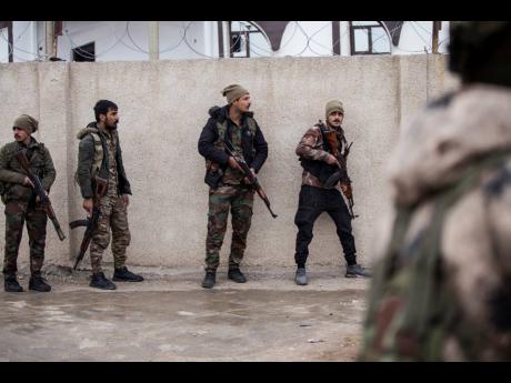 Syrian Democratic Forces soldiers hold a position in Hassakeh, northeast Syria, yesterday. Dozens of armed Islamic State militants remained holed up in the last occupied section of a Syrian prison, US-backed Kurdish-led forces said Thursday. 