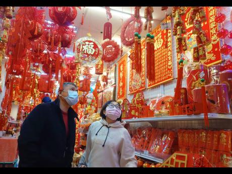 People wear face masks to protect against the spread of the coronavirus as they shop at a decoration store for the upcoming Chinese New Year celebrations.