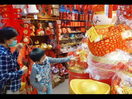 People wear face masks to protect against the spread of the coronavirus as they shop at a decoration store for the upcoming Chinese New Year celebrations.
