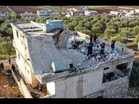People inspect a destroyed house following an operation by US military in the Syrian village of Atmeh, in Idlib province, Syria, yesterday. 