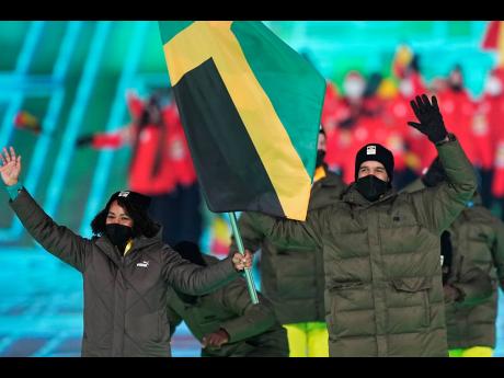 Jamaica's Benjamin Alexander (right) and Jazmine Fenlator-Victorian lead their team during the opening ceremony of the 2022 Winter Olympics on Friday.