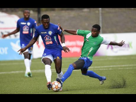 Mount Pleasant’s  Kevaughn Isaacs (left) is tackled by Montego Bay United’s Tavin Shaw during yesterday’s Jamaica Premier League match at the UWI-JFF Captain Horace Burrelll Centre of Excellence. 