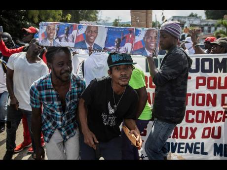 Demonstrators carry around a mock coffin as they protested yesterday for justice in connection with the assassination of late President Jovenel Moise. 