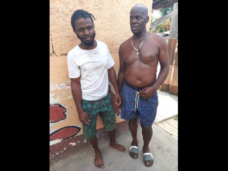 Kemar Campbell (left) is commended by Lenford Thomas for bravely rescuing Ainsley Scott, a Jamaica Public Service Company contract worker, who was electrocuted by a power line in Arnett Gardens last week. Scott succumbed to his injuries on Monday. 